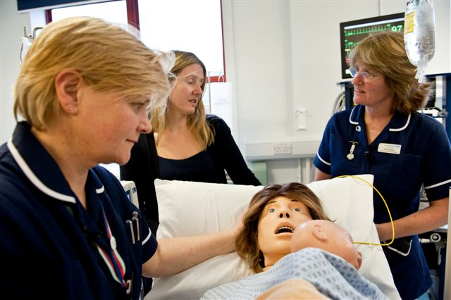 Nurses working with a mannequin of a woman and her baby